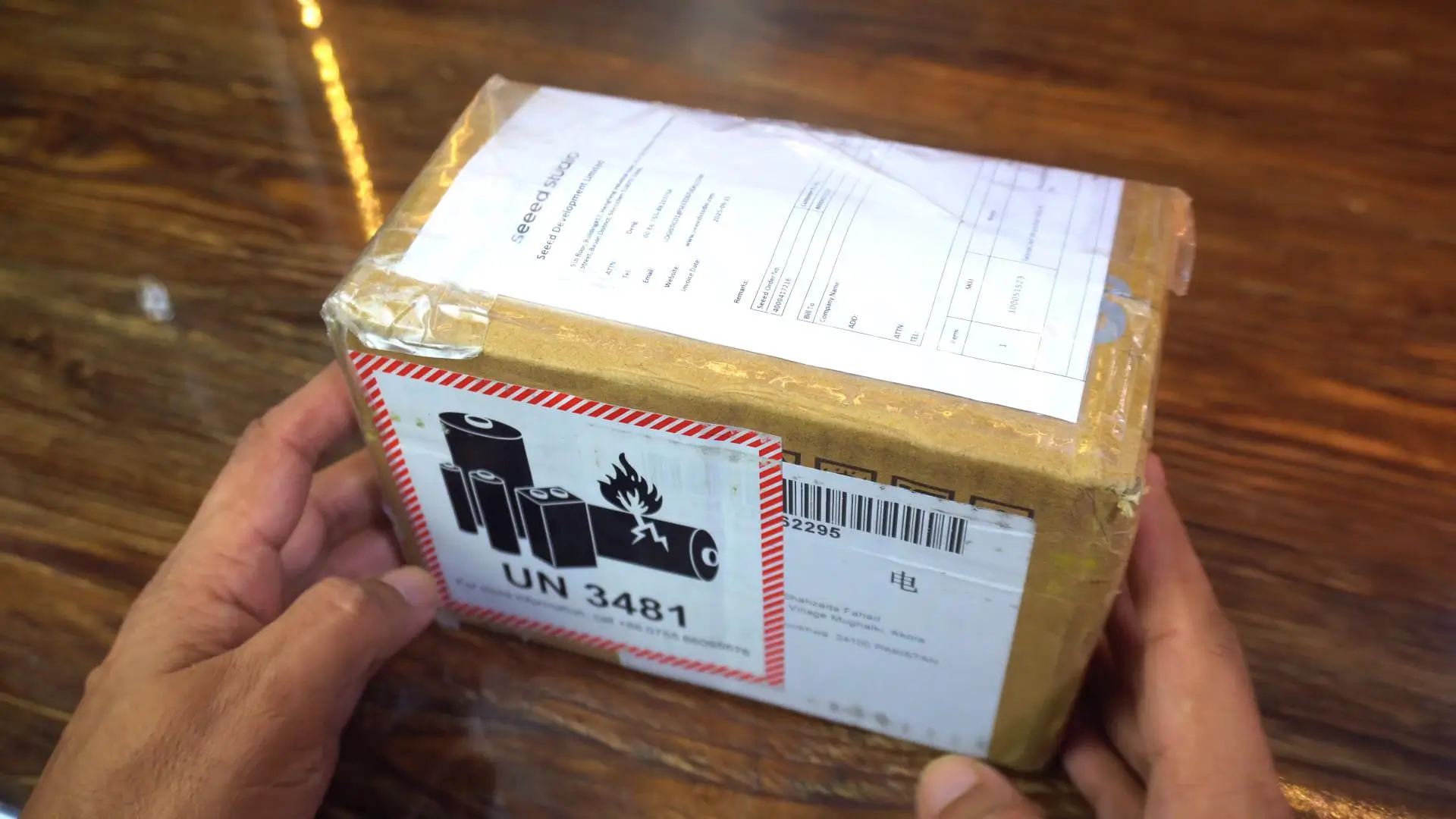 Holding the unopened package from Seed Studio with the SenseCAP Watcher inside.