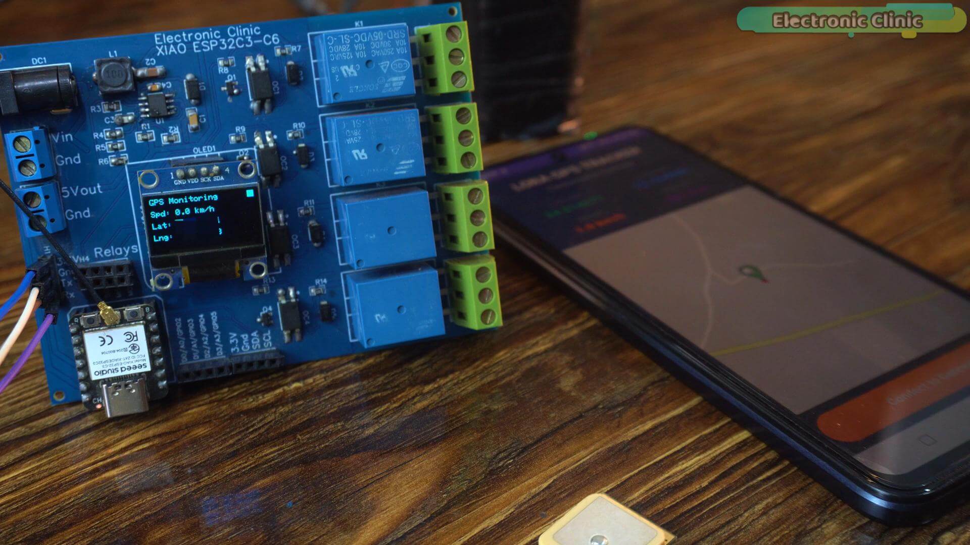 Carrier board OLED and Android companion app bench setup for ESP32 GPS tracking